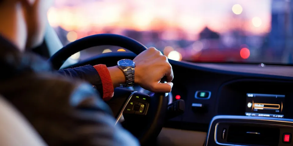 Leerling achter het stuur tijdens een rijles in de avond